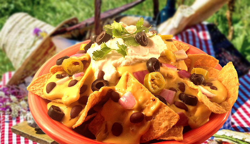 A picnic table with a plate of nachos made with WayFare Dairy Free Sour Cream.