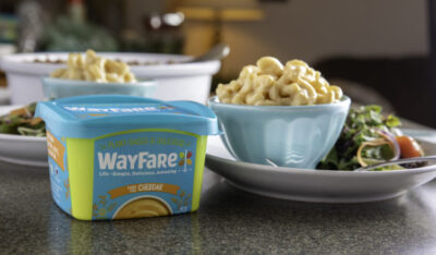 WayFare Dairy Free Cheddar Packaging next to a bowl of mac and cheese made with WayFare Dairy Free Cheddar.