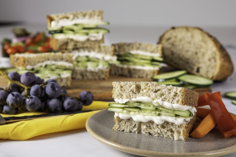Cucumber Sandwiches with dairy free cream cheese from WayFare plated around fruits and veggies.