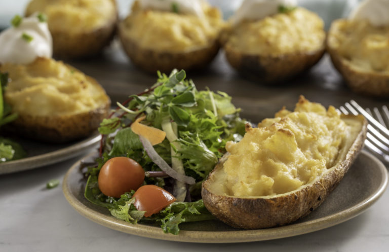 Twice Baked Potatoes with WayFare’s Dairy Free Butter Salted & Whipped on a plate next to a house salad.