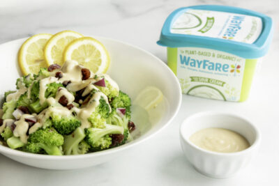 A salad with dressing made from WayFare's Original Sour Cream sitting in a bowl on a white table.