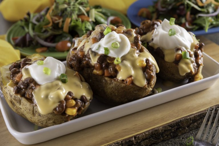 A platter of Vegan Baked Potatoes topped with WayFare Dairy Free Cheddar and Dairy Free Sour Cream.